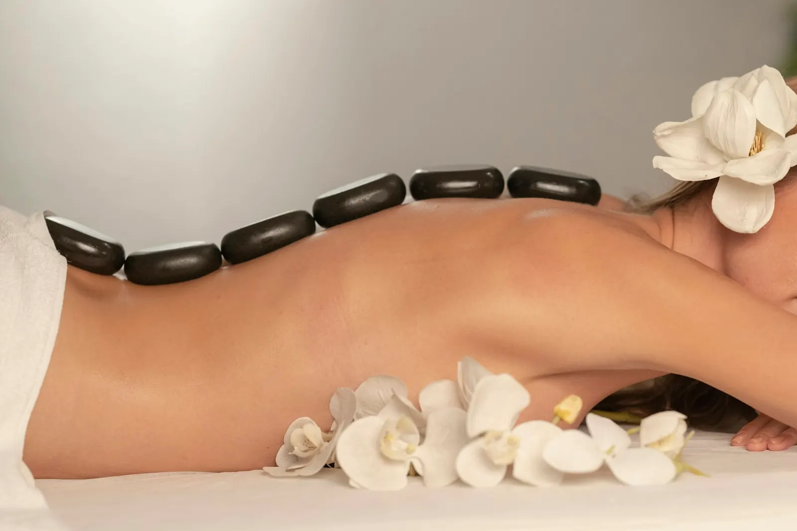 Masaje con piedras calientes y orquídeas blancas